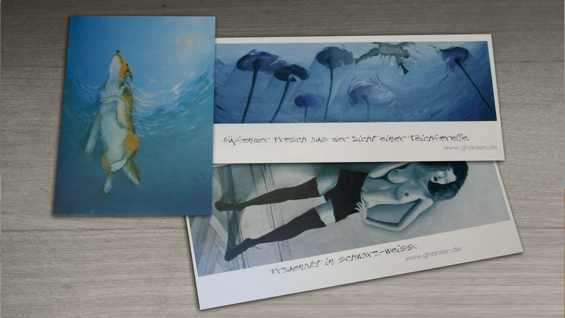 3 Postkarten auf einem Holztisch. Motive: schwimmender Collie von unten, springende Frosch von unten, Frauen-Akt