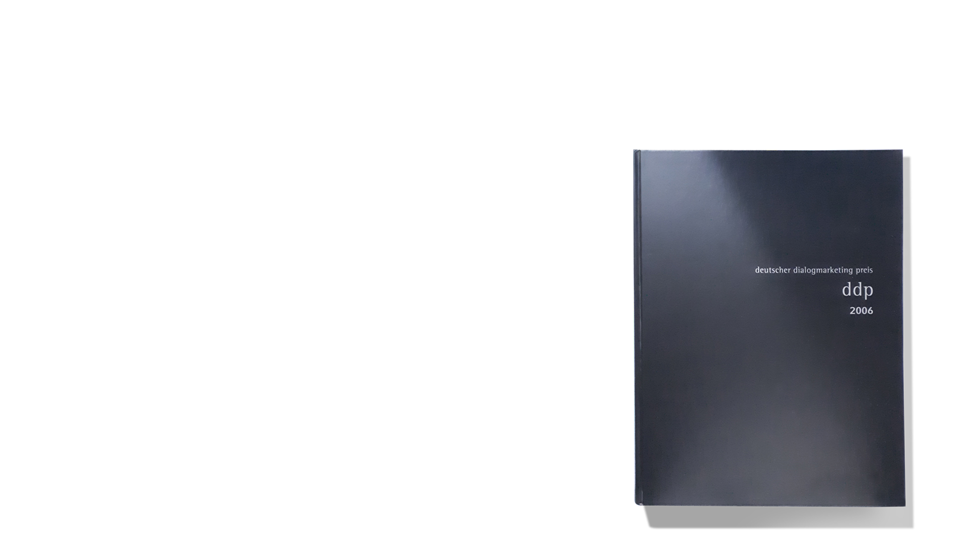 DDP: Geschlossenes schwarzes Buch rechts unten vor weißem Hintergrund