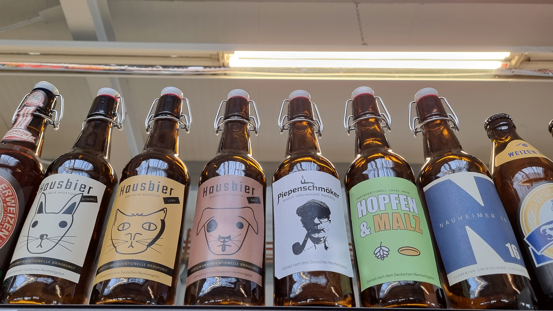 Die Flaschen-Designs am Point of Sale. Die Flaschen stehen in einem Regal mit anderen Bierflaschem, zum direkten Vergleich und als Vorlage für die zweite Testrunde meiner Meinungsforschung.